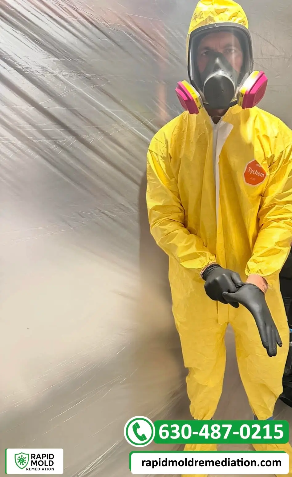Rapid Mold Remediation technician wearing a yellow protective suit and respirator inside a contained work area
